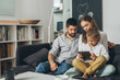 © cherryandbees - cute young family spending time together using tablet computer at home
