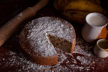 Homemade banana or plantain cake portioned and sprinkled with icing sugar in a circular shape frontal plane