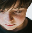 © Cavan Images - Close up of boy with freckles looking downward