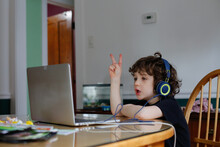 A Young Boy Learning In Front Of A Laptop