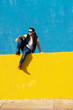 © Cavan Images - Bearded man in white t-shirt, jacket and jeans against blue background