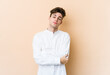 © Asier - Young caucasian man isolated on beige background who is bored, fatigued and need a relax day.