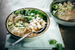© Ina Peters Photographie/Stocksy - Food. Asian rice noodle soup with baby spinach, tofu and onions