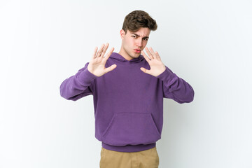 Young caucasian man isolated on white background rejecting someone showing a gesture of disgust.