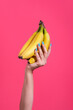 © CACTUS Creative Studio/Stocksy - Hand holding a bunch of banana