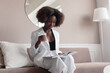 © Viktor Solomin/Stocksy - Young stylish beautiful african american woman have fun, resting and chilling at home at luxury interior
