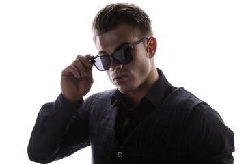 Wall Mural - Portrait of beautyful guy on white background. High fashion model posing in studio. Attractive man in classic suit and sunglasses.