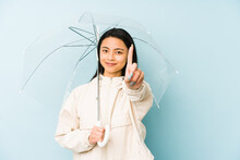 Young Chinese Woman Holding An Umbrella Isolated Happy, Smiling And Cheerful.