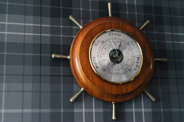 nautical barometer on grey plaid background