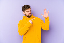 Young Man Isolated On Purple Background Smiling Cheerful Showing Number Five With Fingers.