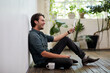 © Bec Hannaford/Austockphoto - Young business man relaxing sitting on a timber floor in studio