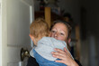 © Caro Telfer/Austockphoto - Woman holding child who opening front door