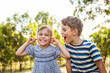 © Clare Seibel-Barnes/Austockphoto - Smiling girl covering her ears with fingers while boy shouting and roaring besides her