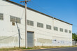 © Gary Chapman/Austockphoto - A power pole outside the door of a large corrugated iron warehouse