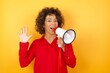 © Roquillo - Young arab woman with curly hair wearing red shirt holding a megaphone over yellow background showing and pointing up with fingers number five while smiling confident and happy.
