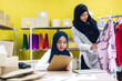 © Art_Photo - Portrait of smiling beautiful two muslim owner asian woman freelancer sme business online shopping working on laptop computer with parcel box on table at home - Business online shipping and delivery