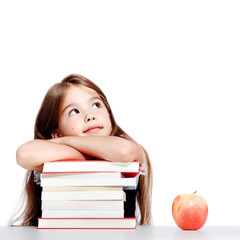 Cute little child girl looking up on the desk at school.