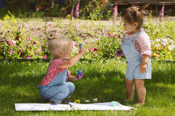 Wall Mural - Two little girls sisters paint with finger paints