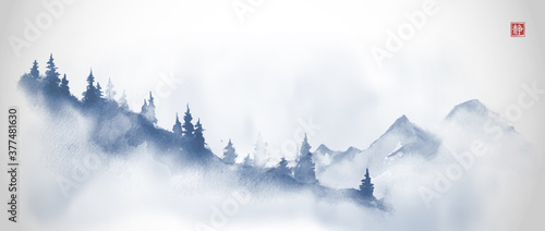 Blue mountain slope with pine trees in fog and far mountains. Traditional ori...