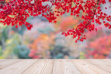 Empty Wood Table Mockup On Red Maple Leaves Background In The Garden With Copy Space For Text, Mock Up For Your Product Display And Montage In Autumn Season, Thanksgiving And Halloween Holiday Concept