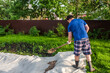 © Kiryakova Anna - A man pours sand onto a geotextile outside. Garden work, do-it-yourself pool