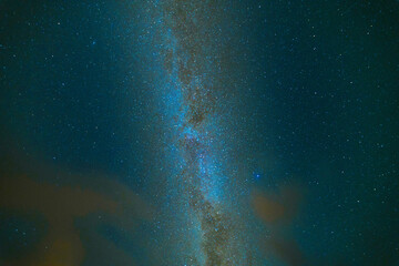 Blue dark night sky with many stars over clouds