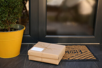 Delivered parcel on door mat near entrance