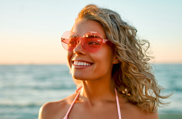 Wall Mural - Attractive Caucasian woman in bikini swimsuit strolls on the beach at sunrise enjoying the sound of the waves.