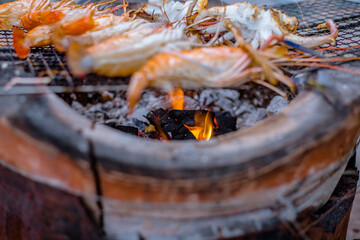 Close-up view of the seafood grill with charcoal stove (shrimp, squid, shellfish) gives it a delicious aroma, eaten with a delicious dipping sauce.