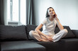 © VERSUSstudio - Young woman pretty relaxing on couch in living room