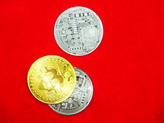 Gold and silver Bitcoin coins on red background 