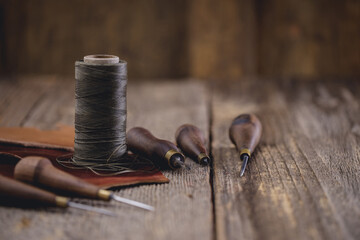 Wall Mural - Leather craft tools on old wood table. Leather craft workshop.