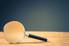 Magnifying Glass On Wood Background