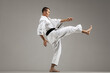 © Nikola Spasenoski - man exercising karate, against gray background