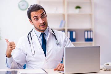 Young male handsome doctor working in the clinic