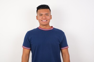 Young handsome hispanic man wearing casual t-shirt standing over white isolated background with a happy and cool smile on face. Lucky person.