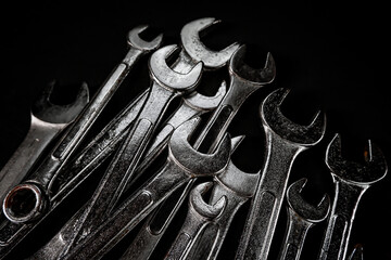 Many wrench metal with black background. Maintenance equipment and repair. Old hand tools.