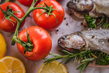 Wall Mural - fresh rainbow fish trout on black stone background with vegetables 