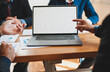 © Wasan - Businessmen point to laptop screen for copy space and discuss with colleagues during meetings.