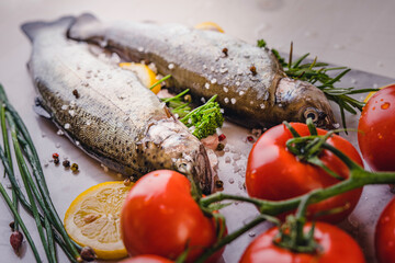 Wall Mural - fresh rainbow fish trout on black stone background with vegetables 