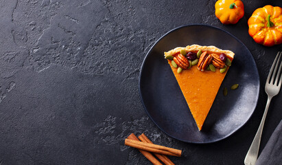 Wall Mural - Pumpkin pie, tart on a plate. Dark stone background. Copy space. Top view.