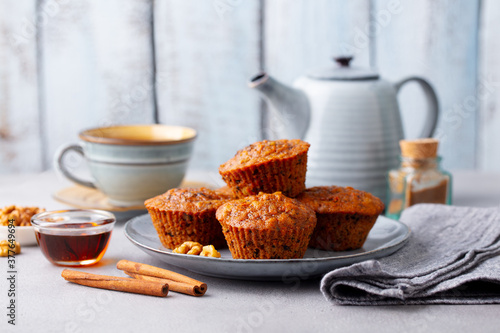 Carrot muffins, cakes with cup of tea. Grey background.