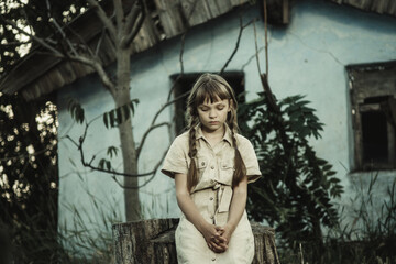 sad teenage girl sitting by an abandoned building