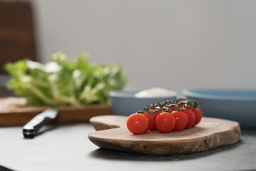 Ripe cherry tomatoes on a branch on wood board