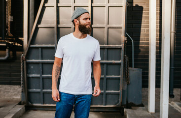 Young bearded hipster guy wearing white blank t-shirt. Mock-up for print. T-shirt template.