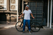 Young bearded hipster guy wearing white blank t-shirt with bicycle . Mock-up for print. T-shirt template.