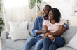 © Prostock-studio - Happy black lovers watching movie together at home