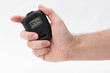 © dnd_project - Man holding digital stopwatch on the white background.