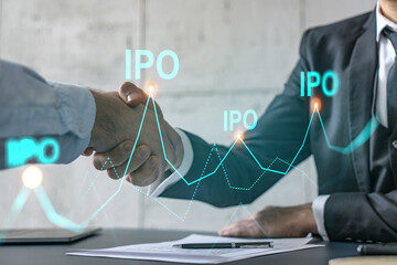 Multiexposure of two businesspeople handshake and initial primary offering, IPO hologram drawing background. Concept of partnership and business boost. Formal wear.