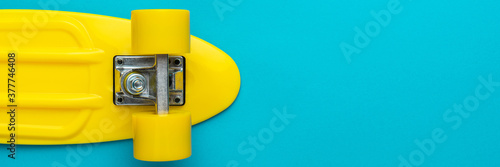 Cuadros en Lienzo Minimalist flat lay photo of yellow plastic mini cruiser board on blue background